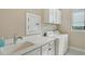Well-lit laundry room featuring white cabinetry, countertops, washer, dryer, and a sink for convenience at 17905 Waterville Pl, Bradenton, FL 34202