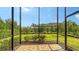 A screened-in porch with brick flooring offers beautiful views of the landscaped backyard at 17905 Waterville Pl, Bradenton, FL 34202