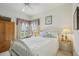 Cozy bedroom showcasing a white bed frame, bright windows, and soft lighting, creating a relaxing atmosphere at 1831 San Silvestro Dr, Venice, FL 34285