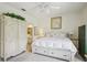 Bright bedroom with neutral tones featuring a white armoire, a dresser, and a white bed with storage drawers at 1831 San Silvestro Dr, Venice, FL 34285