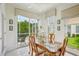 Light-filled dining area with tile floors, glass-top table, and views of the lanai and backyard at 1831 San Silvestro Dr, Venice, FL 34285