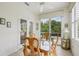 Bright dining area featuring a glass table, wood chairs, and a scenic view of the outdoors at 1831 San Silvestro Dr, Venice, FL 34285