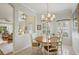 Cozy dining area featuring a chandelier, a wood table with seating for four, and lots of natural light from the large window at 1831 San Silvestro Dr, Venice, FL 34285