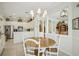 Open-concept dining area with a round wood table, white chairs, and views into the kitchen and living spaces at 1831 San Silvestro Dr, Venice, FL 34285