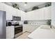 Bright kitchen featuring white cabinets, stainless steel appliances, tile backsplash, and light countertops at 1831 San Silvestro Dr, Venice, FL 34285