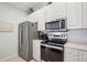 Modern kitchen featuring stainless steel appliances, including a refrigerator, microwave, and oven at 1831 San Silvestro Dr, Venice, FL 34285