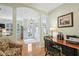 Open floor plan with a view to the office with hard wood floors and a dark wood desk and chair at 1831 San Silvestro Dr, Venice, FL 34285