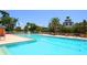 Large community pool with clear blue water, palm trees, and plenty of seating for relaxing at 1831 San Silvestro Dr, Venice, FL 34285