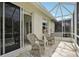 Cozy screened patio with comfortable seating, perfect for enjoying the outdoors in a relaxing and bug-free environment at 1831 San Silvestro Dr, Venice, FL 34285