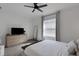 Bright, carpeted bedroom features a large window, dresser with TV, and neutral decor at 1860 Pleasant Maple Ct, Bradenton, FL 34211
