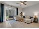 Comfortable living room with large window, patterned rug, ceiling fan, and access to the outdoor patio at 1860 Pleasant Maple Ct, Bradenton, FL 34211