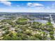 Picturesque aerial shot of a neighborhood with beautiful pond views surrounded by lush trees under a bright blue sky at 1930 Peppermill Dr, Clearwater, FL 33763
