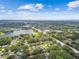 Breathtaking aerial perspective of a neighborhood with a serene lake and winding roads surrounded by lush greenery at 1930 Peppermill Dr, Clearwater, FL 33763