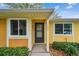 Welcoming front entrance with a black door, complemented by lush landscaping and clear house numbers at 1930 Peppermill Dr, Clearwater, FL 33763