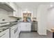 Bright, updated kitchen with white cabinets, granite countertops, subway tile backsplash, and stainless steel appliances at 1930 Peppermill Dr, Clearwater, FL 33763