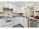 Updated kitchen with white cabinets, granite countertops, stainless steel appliances, and subway tile backsplash at 1930 Peppermill Dr, Clearwater, FL 33763