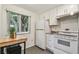 Bright kitchen featuring white appliances, granite countertops, a breakfast nook, and a large window at 1930 Peppermill Dr, Clearwater, FL 33763