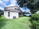 Spacious backyard featuring manicured lawn, mature landscaping, and a screened-in porch at 2160 Brandon Park Cir, Brandon, FL 33510