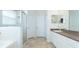 Bright bathroom features a shower, soaking tub, vanity with storage, and neutral tile flooring at 2160 Brandon Park Cir, Brandon, FL 33510