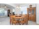 Bright dining room features a round wooden table, chandelier, and large windows that let in natural light at 2160 Brandon Park Cir, Brandon, FL 33510