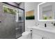 Modern bathroom features a glass shower with gray tiling and a vanity with a lighted mirror at 2182 Wisteria St, Sarasota, FL 34239