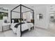 Comfortable bedroom with a four-poster bed, soft rug, and natural light from the windows at 2182 Wisteria St, Sarasota, FL 34239