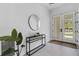 Entrance foyer with modern decor, a round mirror, and a console table at 2182 Wisteria St, Sarasota, FL 34239