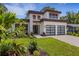 Modern two-story home featuring a well-manicured lawn, decorative plants, and a two-car garage at 2182 Wisteria St, Sarasota, FL 34239
