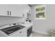 Functional laundry room features modern washer and dryer, storage cabinets, and a utility sink at 2182 Wisteria St, Sarasota, FL 34239