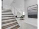 Elegant staircase with wood treads and glass railings, with a view of the living room at 2182 Wisteria St, Sarasota, FL 34239
