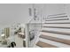 Bright staircase with wood treads and glass railings offering views of the living and dining areas at 2182 Wisteria St, Sarasota, FL 34239