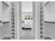 Bright walk-in closet with adjustable shelving leading to a bedroom with natural light at 2182 Wisteria St, Sarasota, FL 34239