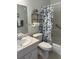Bathroom features a vanity with storage, decorative shelving, and a shower with a floral curtain at 2218 Orange Blossom Ln # 0, Bradenton, FL 34207