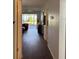 Hallway with hardwood flooring, leading to an open living area and sliding glass doors to the screened patio at 2218 Orange Blossom Ln # 0, Bradenton, FL 34207