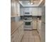 Bright kitchen features white cabinetry, appliances and tile flooring at 2218 Orange Blossom Ln # 0, Bradenton, FL 34207