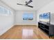 Light-filled bedroom boasts hardwood floors, ceiling fan, large window, and a TV mounted on the wall at 226 Golden Gate Pt # 63, Sarasota, FL 34236