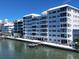 Elegant multi-story building with waterfront access, featuring balconies and a charming dock at 226 Golden Gate Pt # 63, Sarasota, FL 34236