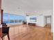 Spacious living room with hardwood floors, large windows offering beautiful water views, and a fireplace at 226 Golden Gate Pt # 63, Sarasota, FL 34236
