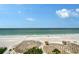 Breathtaking beach view showcasing white sands, turquoise waters, and inviting thatched umbrellas at 2425 Gulf Of Mexico Dr # 6A, Longboat Key, FL 34228