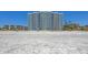 Spacious sandy beach with sun huts and lounge chairs in front of condos under blue skies at 2425 Gulf Of Mexico Dr # 6A, Longboat Key, FL 34228