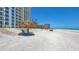 Relaxing beach with huts and lounge chairs in front of condos and blue skies at 2425 Gulf Of Mexico Dr # 6A, Longboat Key, FL 34228