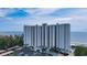 Modern condo building with floor-to-ceiling windows and well-maintained landscaping at 2425 Gulf Of Mexico Dr # 6A, Longboat Key, FL 34228