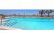 Stunning swimming pool with lounge chairs, umbrellas, and swaying palm trees overlooking the ocean at 2425 Gulf Of Mexico Dr # 6A, Longboat Key, FL 34228