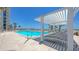 Beautiful swimming pool with lounge chairs under a shade structure by the sunny beach at 2425 Gulf Of Mexico Dr # 6A, Longboat Key, FL 34228