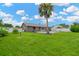 Expansive backyard with a pool, large palm tree, and lush green lawn, perfect for recreation at 2522 51St Street E Ct, Palmetto, FL 34221