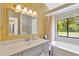 Well-lit bathroom with large mirror, walk-in shower, soaking tub, and view of yard at 2522 51St Street E Ct, Palmetto, FL 34221