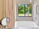 Bright bathroom with a soaking tub, shower, and large window with view of yard at 2522 51St Street E Ct, Palmetto, FL 34221