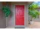 Vibrant red front door complemented by green plants, offering a warm and inviting entrance at 2522 51St Street E Ct, Palmetto, FL 34221