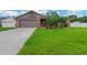 Charming single-Gathering home featuring a lush green lawn and a welcoming red front door at 2522 51St Street E Ct, Palmetto, FL 34221