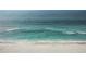 Aerial view of calm turquoise ocean water meeting a pristine white sandy beach with small waves gently rolling in at 302 And 304 Canal Rd, Sarasota, FL 34242
